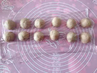 猪猪椰蓉小面包,面团排气后平均分成31克的12个小面团，覆盖保鲜膜松弛15分钟。