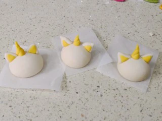 零色素卡通馒头可爱独角兽馒头,然后粘贴部分刷点水,在头顶正中间粘上角,两侧粘上耳朵。