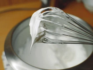 抹茶魔法蛋糕,加入剩余的细砂糖。 打发到提起打蛋头形成小尖椒,小弯钩。 打发到干性发泡,这样才能混合不均匀,飘在蛋糕糊表面,形成海绵蛋糕层。