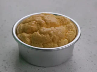 火龙果渐变蛋糕(宝宝辅食),依然是因为无糖的原因,做出的戚风蛋糕表面凹凸较多,但是不影响后面操作,烤好的蛋糕取出倒扣晾凉