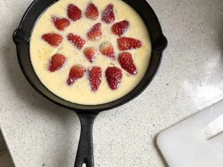 草莓克拉夫提,倒入预热好的容器里，在上面铺一层草莓。 