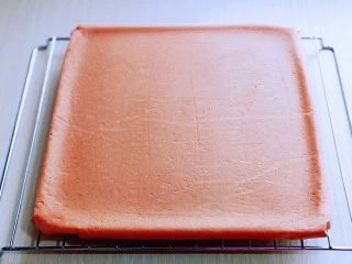 红丝绒草莓奶油蛋糕卷~下午茶必备甜品,取出烤盘趁热将油纸撕掉,放烤网了晾至有余温。