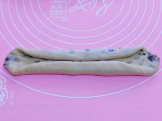 红豆日式咖啡面包卷,取一块面团,用擀面杖擀长舌状。