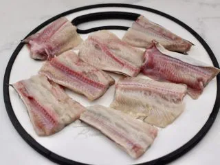 日式柠香烤鳗鱼,海鳗去内脏洗净后，从头部平行下刀，沿鱼肚方向切开，即可得到整片的海鳗鱼排，用刀切大块。