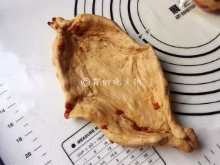 红糖枸杞软欧包,随后用手轻轻按成椭圆形，捏出四个角来。