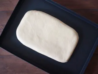 丹麦手撕吐司,将配方中除黄油和裹入黄油的材料一起揉成面团，能拉出厚膜，再加入黄油继续揉至扩展阶段，然后放在烤盘中擀成长方形，盖好保鲜膜放入冰箱中冷冻一小时左右