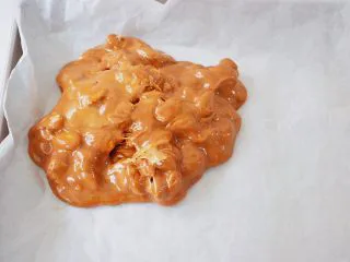 海盐杏仁太妃糖,烤盘铺上一张油纸，再把太妃糖放入