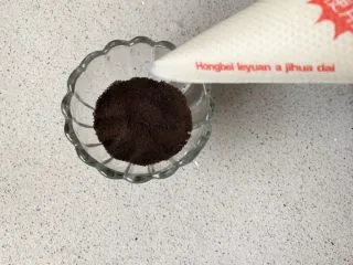 奥利奥木糠杯,先放2勺饼干碎,用勺子压压平