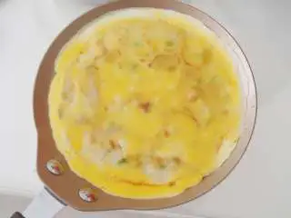 意酱鸡蛋卷饼,一面煎熟后翻面，磕上适量打散的鸡蛋