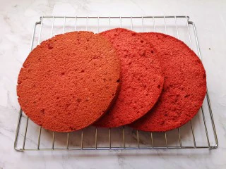 红丝绒水果裸蛋糕,时间到,从烤箱里取出模具(注意烫手),垂直摔一下震出热气,倒扣在晾网上,凉透之后反过来脱模,将脱模的蛋糕胚分成三片(如图)。