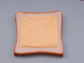 田园时蔬吐司披萨,上面再铺上奶酪片。