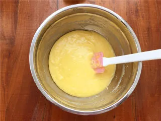 柠檬玛德琳甜甜圈,倒入面糊中。翻拌至黄油和面糊完全融合在一起。这个过程一定要有耐心。拌好的面糊可以放到阳台冷去一下(夏天就放冰箱)。用刮刀铲起面糊,面糊不会滴落即可。