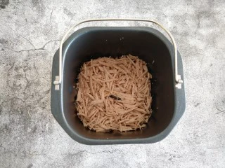 自制海苔肉松,把处理好的里脊倒入面包桶内。