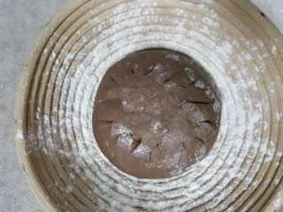 天然酵种割口欧包,发酵篮中洒高筋面粉,将面团光滑面朝下,放入发酵篮中进行发酵。