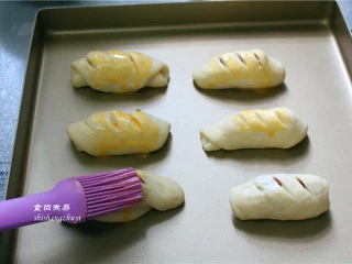 脆皮肠小面包,面包表面刷一层鸡蛋液；