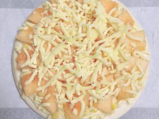 蜜瓜蔬果披萨,最上面再撒上一层芝士碎。