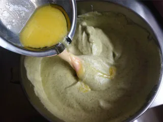 丸久小山园名物蛋糕卷--抹茶,将牛奶黄油沿着橡皮刮刀加入到面糊中,翻拌混合均匀。