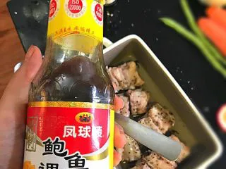 鲍汁焗小排淋酸甜洋葱酱,10分钟后拿出来(要戴隔热手套拿,千万小心别烫到)。给猪小排上下均匀抹上鲍鱼汁。不用太多,一共一勺就好了。不然会咸。然后再次放入烤箱,180度烤25分钟。