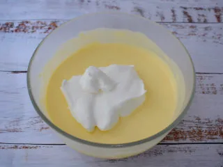 酸奶芝士蛋糕,把三分之一蛋白倒入奶酪糊中拌匀