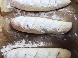 当主食一次可以吃三个的法棍面包,发酵好之后,撒上少量面包粉,割口。烤箱上火200度,下火180度预热,烤22分钟左右。 烘烤的同时,下面放一个烤盘,发酵时用的沸水倒进去,这样可以使面包更加松软。 具体时间视自己烤箱的温度而定。