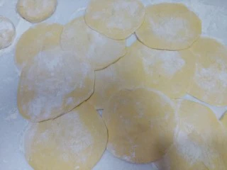 南瓜芹菜肉包子,揪成剂子后用擀面杖擀成中间厚边缘略薄的包子皮