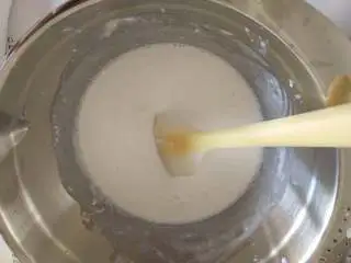 抹茶荔枝慕斯蛋糕,牛奶溶液分两次倒入奶油白巧克力糊中,先倒一少半拌匀,然后再倒剩余的,翻拌均匀成慕斯糊