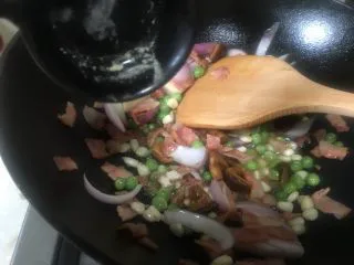 芝士培根焗饭,倒入生抽翻炒片刻，炒香炒熟食材。