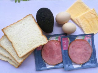 牛油果鸡蛋火腿三明治,准备材料:吐司4片, 牛油果1个, 鸡蛋2个、 火腿2片、芝士2片。
