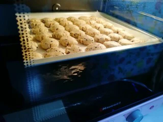 芝麻核桃一口酥,烤了10分钟的时候,一口酥开始变色变大了。