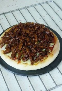 玄妙感觉的孜然羊肉披萨,将羊肉整齐码放,撒上一层马苏里拉奶酪。