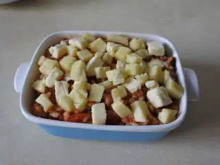 茄汁培根焗饭,盛入碗中，撒上两种奶酪