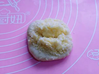 花式椰蓉面包,取一块面团,用掌心压扁,放上椰蓉馅!