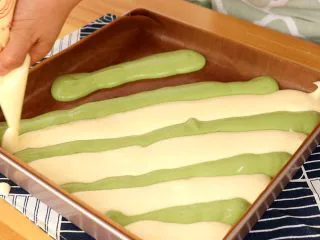 圣诞草莓蛋糕卷,分条隔开挤入铺油垫的烤盘上 