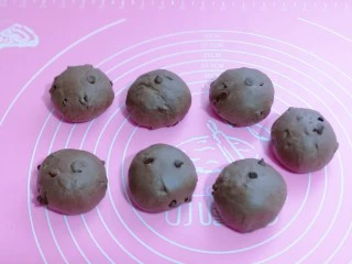 懒人必做~巧克力贝果,将揉好的面团取出,分割7等份,面团的大小也可以根据个人喜欢。盖上湿布醒发10分钟。