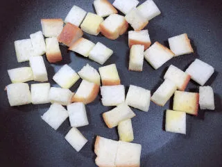 鸡蛋牛奶布丁,放入面包块儿，小火儿煎烤面包块至金黄色。