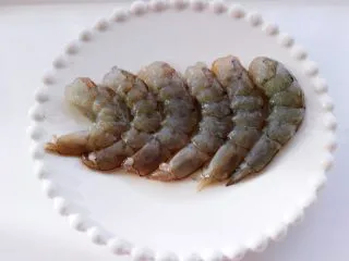 海虾杂蔬披萨,依次把其它的海虾都处理干净后,用胡椒粉和料酒腌制一会。