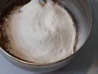 巧克力熔岩杯子蛋糕,筛入低筋面粉后用刮刀翻拌均匀