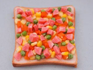 田园时蔬吐司披萨,再撒上火腿丁。