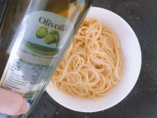 番茄蘑菇肉酱意大利面,先把意面放入一个碗中,加入适量橄榄油搅拌一下,防止粘连