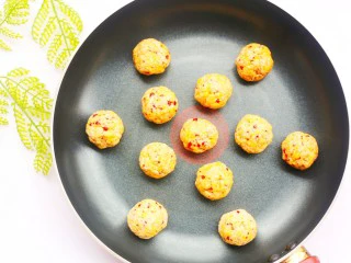 酸甜可口的草莓脆米粉球,米粉球放入平底锅小火慢煎，中途多摇动锅使米粉球受热均匀。