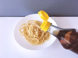 西餐之黑椒鸡丝意大利面,将煮好得意大利面捞出冲冷水，在用盘子装起来，淋上少许香油