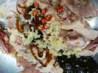 生焗啫啫湛江鸡,上面所有调料放进去加一点泰椒碎 沙姜碎 姜米拌匀加生粉 拌匀加花生油老抽调色