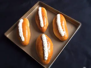 奶油夹心面包,奶油霜装入裱花袋中，挤入面包开口处，再表面装饰一下。