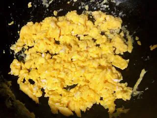 番茄鸡蛋拌意面,锅中倒入适量底油加热再倒入蛋液炒至八分熟盛出装入容器中