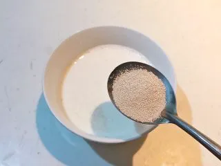 香肠苹果披萨,碗里加入纯牛奶60克,加入3克酵母粉