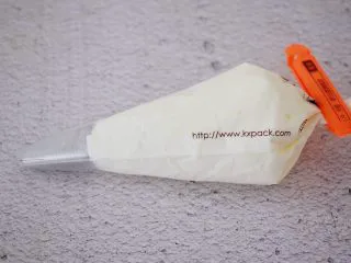 黑芝麻慕斯蛋糕,裱花袋加入中号圆形裱花嘴,再把淡奶油装入