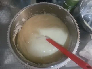 烘焙基础——戚风蛋糕,以翻拌和切拌(所谓切拌就是左手转动打蛋盆,右手拿刮刀画“一”字,横着画完再竖着画,“先翻拌再画一”)的方法拌均面糊即可。