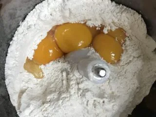 自制意大利面条,把面粉扒一个窝，放入橄榄油和鸭蛋黄。