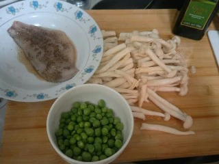 健康低卡香煎鲈鱼,准备腌制好的鲈鱼片，一小碗小豌豆。和一把海鲜菇