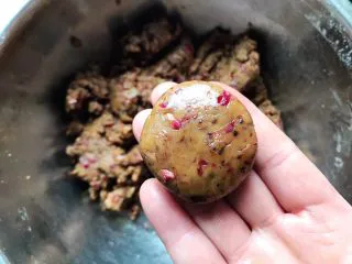 玫瑰花红糖小酥饼,取25g面团，用手搓圆之后稍微按扁，将边缘开裂的地方轻轻捏几下，形成一个扁圆形